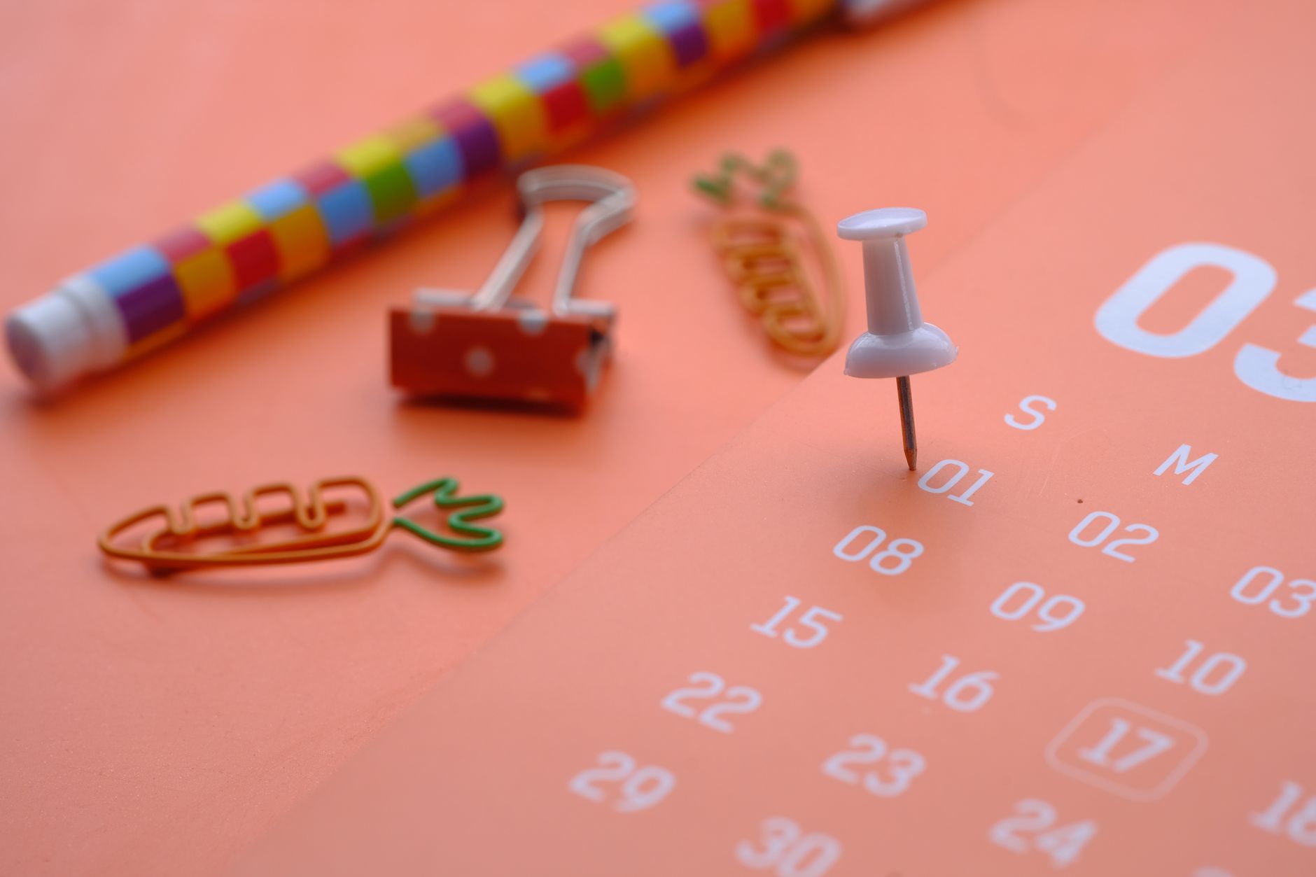 Eine Nahaufnahme von bunten Bürobedarf mit einem Kalender, ideal für Planung und Organisationsthemen.