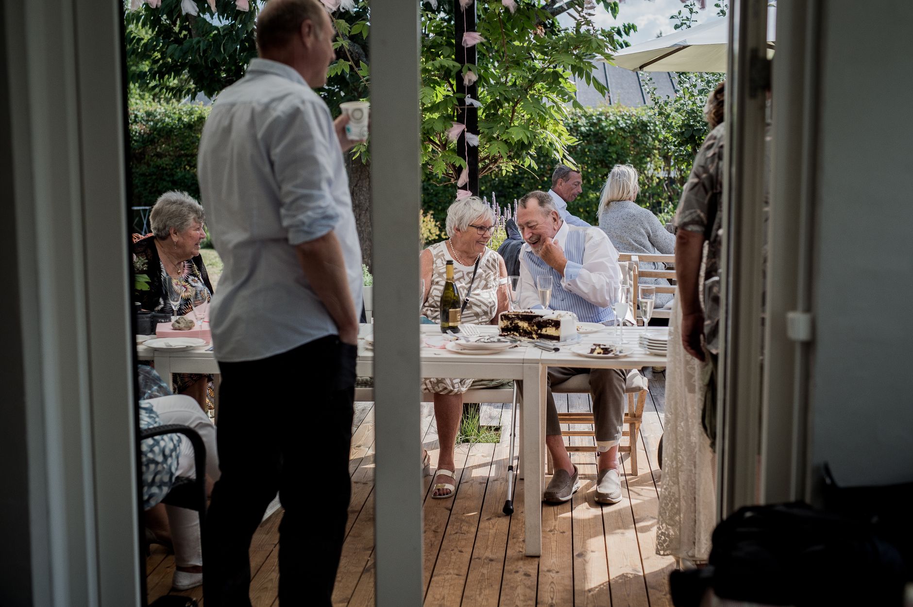 Ein entspanntes Treffen im Freien mit Freunden, die Essen und Getränke in einer Gartenumgebung genießen.